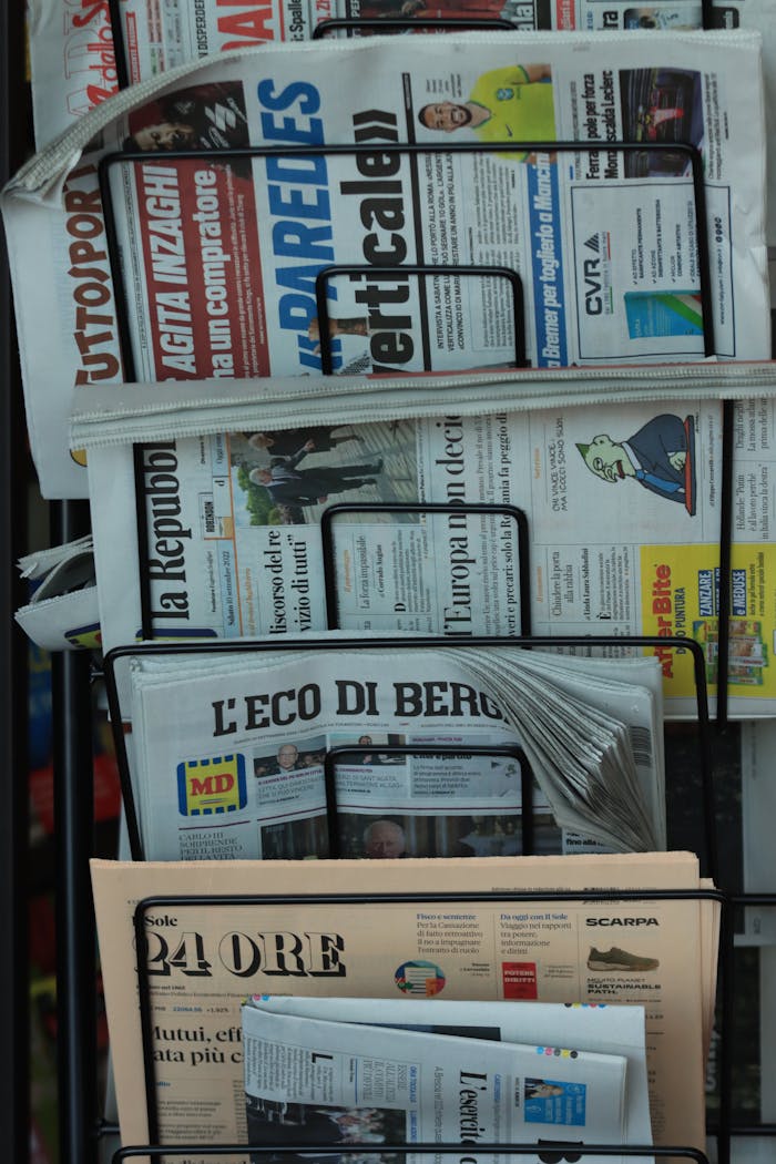 Stack of Italian newspapers on a street kiosk in Turin, Italy, highlighting daily news.